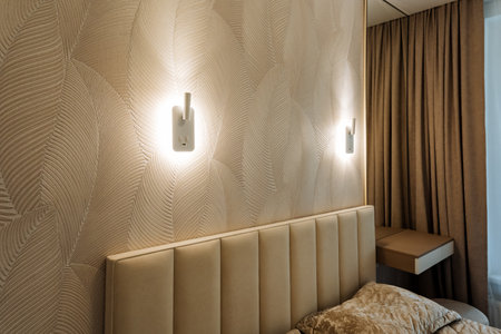 A cozy bedroom featuring a comfortable bed alongside a stylish mirror that is elegantly mounted on the wall, adding to the overall charm of the room and enhancing its aesthetic appealの写真素材