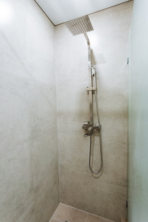 This expansive bathroom features a contemporary design with a modern shower head and elegant glass door, enhancing style, comfort, and functionality for a perfect selfcare retreatの写真素材