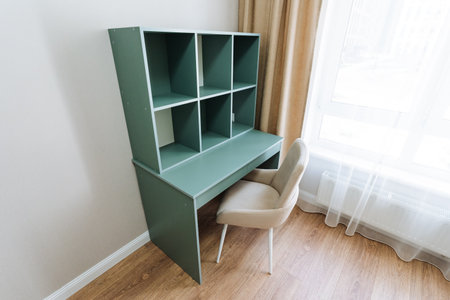 The room includes a wellequipped desk with a comfy chair and a charming bookshelf, creating a cozy workspace ideal for reading, writing, or studying, complemented by warm, inviting furnishingsの写真素材