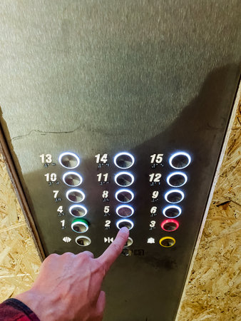 A person confidently uses the elevator, pressing a button for a selected floor, showcasing their...
