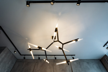 A stunningly beautiful chandelier elegantly hangs from the ceiling, serving as an exquisite lighting fixture that greatly enhances the overall design and inviting ambiance of the entire spaceの写真素材