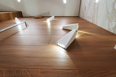 A beautiful wooden floor that features a few soft lights illuminating it, creating an inviting atmosphere and enhancing the natural wood grain patterns for an appealing aesthetic finishの写真素材