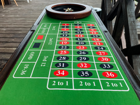 A classic roulette table showcases a beautifully crafted wheel atop its surface, inviting enthusiastic players to partake in this engaging and entertaining game that blends both chance and strategyの写真素材