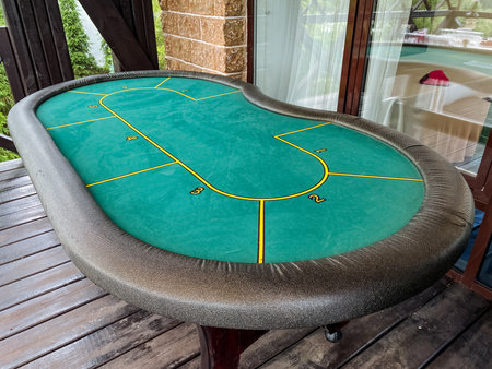 An attractive green poker table featuring distinct yellow lines designed on its surface, perfect for indoor games and sports enthusiasts, adding a lively touch to any recreation room settingの写真素材