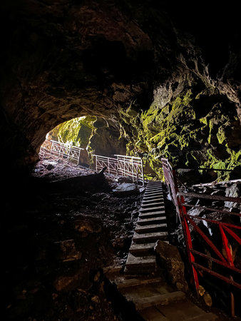 There is a fascinating cave featuring a set of stairs that gracefully leading up to its grand entrance, creating a striking view that showcases the natural beauty of the surrounding geological formationの写真素材
