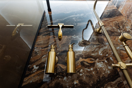 A curated collection of modern gold bathroom fixtures on a marble countertop showcases elegance, sophistication, and contemporary style, ideal for upscale renovations and chic living spacesの写真素材