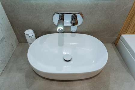 The elegantly designed bathroom features a pristine white sink and a sleek modern faucet, combining essential functionality with aesthetic appeal for the overall design and atmosphereの写真素材