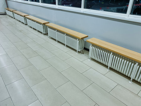 As you walk through the hallway, you will notice a long row of radiators lining the walls, accompanied by sturdy benches positioned beside them, providing both warmth and seating for passersbyの写真素材