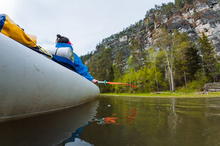 Enjoy a day of fishing in a cozy canoe, surrounded by greenery and cliffs. This serene setting is ideal for nature lovers and outdoor enthusiasts seeking adventure in beautiful landscapesの写真素材