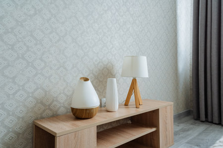 In a cozy living room, there is a beautiful wooden table adorned with vases and stylish lamps placed on it, creating a warm and inviting atmosphere for relaxation and social gatheringsの写真素材
