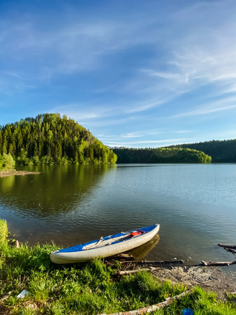 A kayak is sitting on the shore of a lakeの写真素材