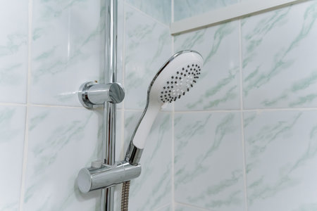 This stunning closeup of a shower head in a beautifully designed bathroom showcases its sleek modern look and superior functionality, making it an ideal choice for home renovationsの写真素材