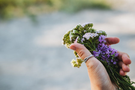 A person holds a vibrant bouquet of colorful flowers, showcasing stunning arrangements of natures finest blooms, lush leaves, and delicate petals, reflecting beauty and elegance in every detailの写真素材