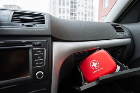 Inside the glove compartment of the car, there is a red first aid kit that is ready for any emergencies that may arise during your travels. It is a crucial item for safety on the roadの写真素材
