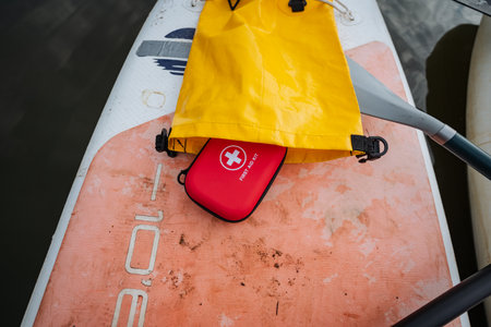 A bright yellow bag is resting atop a paddle board, waiting for its owner to come back and retrieve it before setting out on an exciting adventureの写真素材
