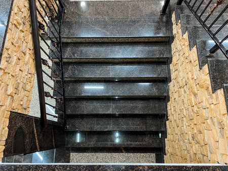 The stairs, which feature a beautiful combination of marble and wood materials, are accompanied by a sturdy metal railing that provides both safety and style while ascending or descendingの写真素材