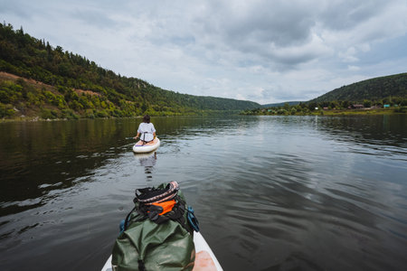 Experience a serene kayaking adventure on calm, tranquil waters. You will be surrounded by breathtaking natural scenery, creating the perfect getaway into nature that rejuvenates the soul and mindの写真素材