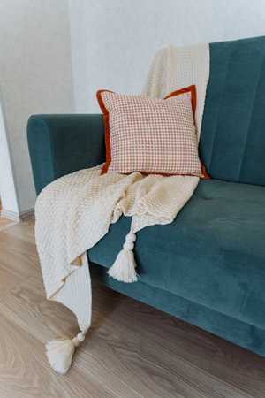 The spacious and open living area features a comfortable couch with a soft pillow and a cozy throw blanket, creating an inviting and relaxing spot perfect for unwinding after a long and tiring dayの写真素材