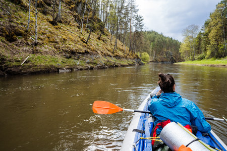 Enjoy a peaceful kayaking adventure on a tranquil river, surrounded by lush greenery and cliffsan...