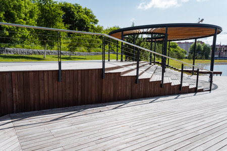 A wellconstructed wooden deck featuring stairs, along with a sturdy railing, is situated in a...