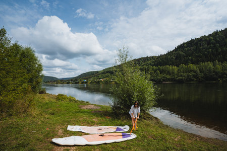 Enjoy a serene experience at the tranquil lake, where colorful paddleboards contrast with lush...