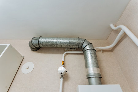 A sturdy and robust metal pipe is securely mounted and hangs from the ceiling, serving as an interesting architectural feature that may link to vital plumbing or electrical systems within the roomの写真素材