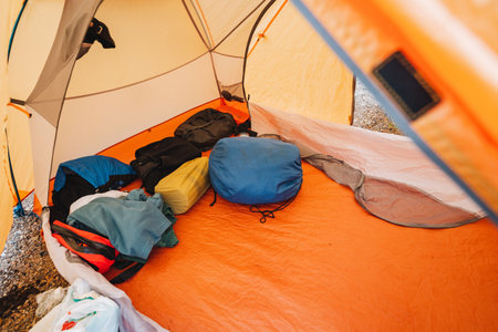 Inside the tent, a chaotic yet cozy mix of clothes, bags, and gear creates a welcoming, cluttered camping space that is ideal for enjoying the great outdoors together with friends and familyの写真素材