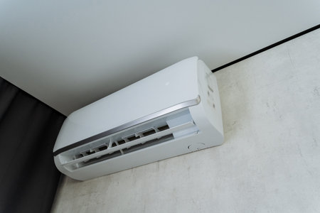 A sleek, modern air conditioning unit mounted on a wall, featuring a minimalist design that emphasizes functionality and aesthetics, ideal for enhancing stylish contemporary living spacesの写真素材