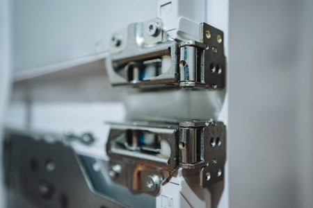 This detailed view of premium stainless steel door hinges highlights their durability and smooth operation, making them perfect for contemporary cabinetry and modern furniture designの写真素材