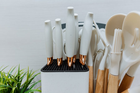 This stylish kitchen utensil holder showcases white utensils with rose gold accents. Its organized,...
