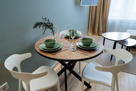 This stunning modern dining table, perfectly paired with vibrant green dishware and elegant, stylish glasses, greatly inspires contemporary design enthusiasts and creative individuals alikeの写真素材