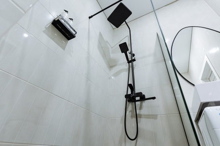 Discover an exquisite shower design that incorporates stylish black fixtures paired with pristine...