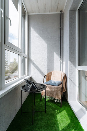 The expansive balcony, featuring a cozy chair and a chic table, provides a tranquil outdoor area where one can savor the fresh air and take in the stunning scenic views all around themの写真素材
