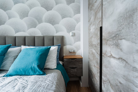 This beautifully designed bedroom features a comfy bed for restful sleep, a stylish nightstand for essentials, and an elegant marble wall that enhances the rooms sophistication and charmの写真素材
