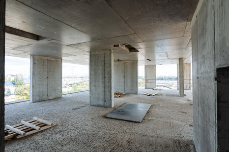 This expansive and large empty room is located within a building that is currently undergoing the process of construction, showing its unfinished elements and potential for future developmentの写真素材