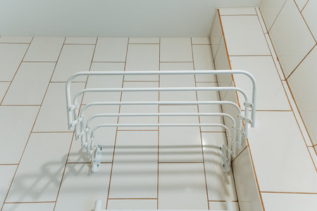 A white towel rack atop a stylish tiled floor enhances the aesthetic and practicality of a beautifully designed bathroom, making it an ideal addition for homeowners and decoratorsの写真素材