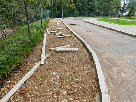 A concrete curb is being installed alongside a road to enhance safety and organization within the public space for pedestrians and vehiclesの写真素材