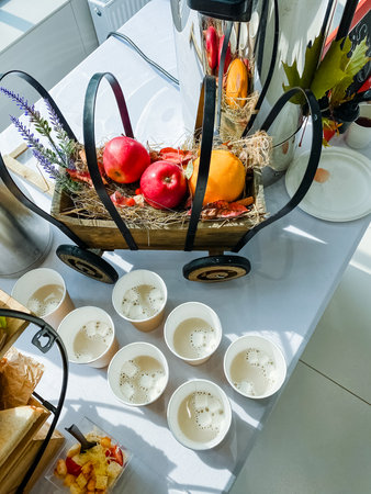 A beautifully set dining table with steaming soups and vibrant fruits creates a warm atmosphere for...