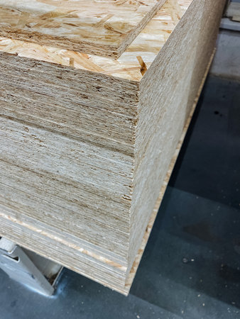 A stack of plywood boards is currently resting on the surface of a sturdy table, showing a variety...