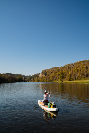 Enjoy a serene family kayaking adventure on a beautiful lake surrounded by autumn foliage, perfect...