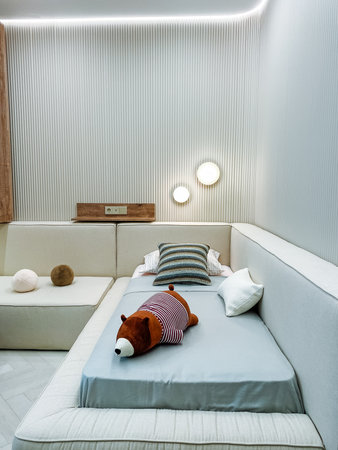 This modern bedroom features a light color palette, plush textiles, and a playful teddy bear, blending comfort with contemporary design for an inviting, cozy, and sophisticated atmosphereの写真素材
