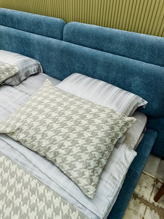 Imagine a beautifully arranged bed with soft lines and decorative pillows against a textured wall, creating a serene, inviting bedroom ambiance that encourages relaxation and comfortの写真素材