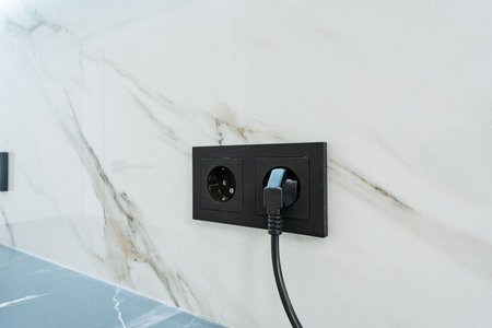 The image features a closeup of a sleek black electrical outlet with a plug, set against a stunning...