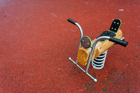 An intricately crafted wooden rocking horse is beautifully positioned on a vibrant red surface, perfect for imaginative play and creating a sense of balance.の写真素材