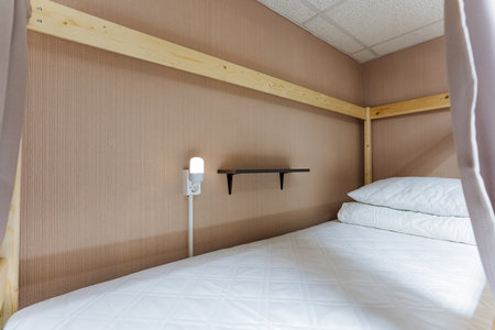 In a cozy room filled with warmth, a charming bunk bed is adorned with crisp white sheets and fluffy...