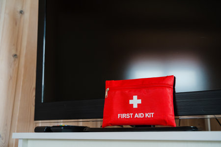 A bright red first aid kit on a stylish TV stand highlights the importance of safety and preparedness in a contemporary living space, ensuring readiness for any emergency that may ariseの写真素材