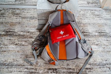 This stylish gray backpack features vibrant orange accents and includes a red first aid kit for safety during outdoor activities and adventuresの写真素材