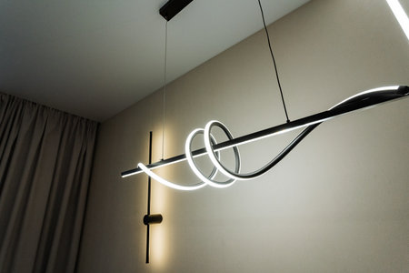 This stunning pendant light features a modern design with elegant curves, perfect for enhancing contemporary interiors and adding sophistication to any room, elevating the overall ambianceの写真素材