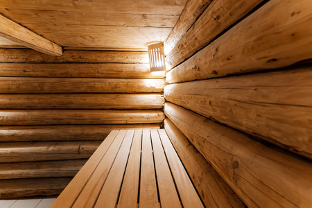 closeup of warm log sauna wooden bench, pristine wooden bench illuminated softly in log sauna setting, detailed view of cozy and warm wooden bench inside log sauna with gentle lightingの写真素材