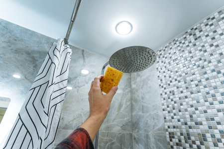 assessing mosaic wall waterproofing, professional evaluation of shower waterproofing and tiles, thorough assessment of mosaic walls and waterproofing integrity by professional inspectorの写真素材